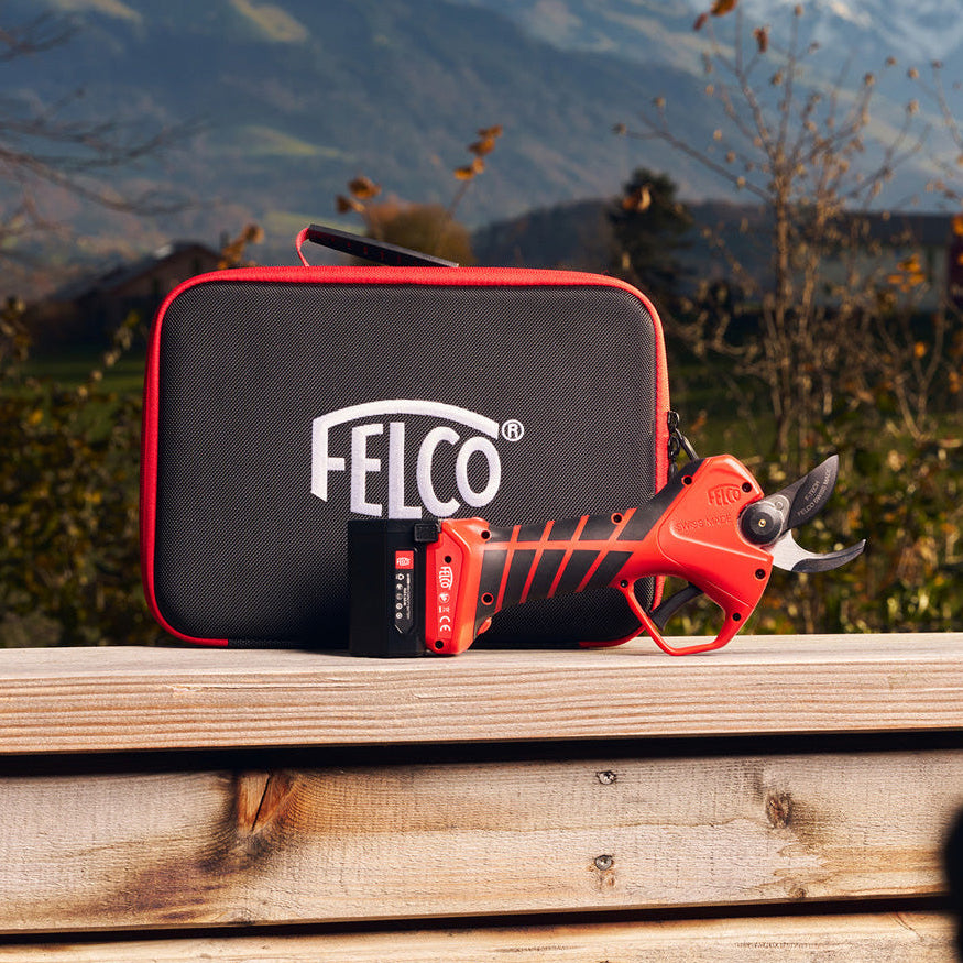 Felco pruning shears with black carrying case on a wooden surface with mountains in the background