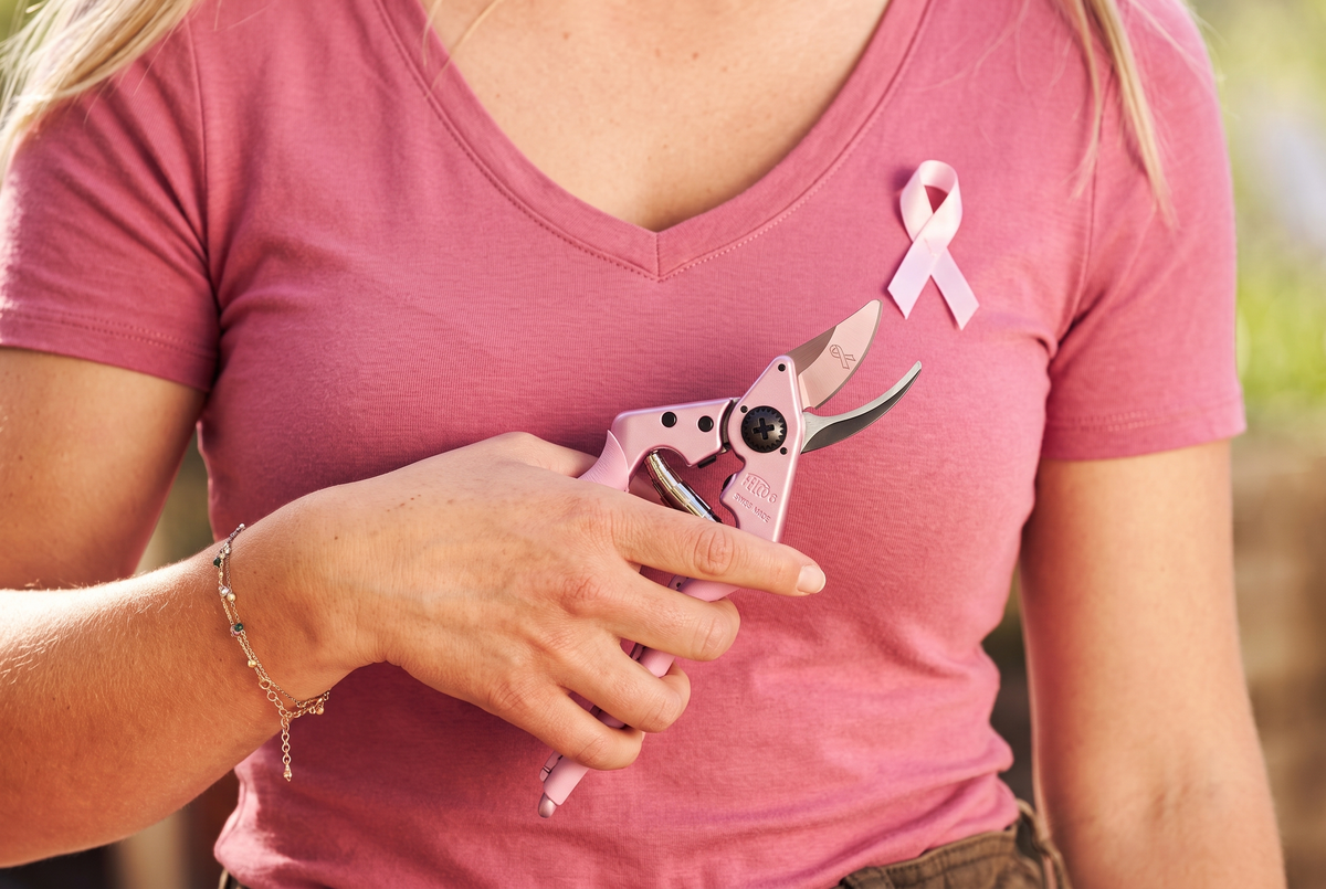 Pink Blossom pruning shears held beside a pink breast cancer awareness ribbon.